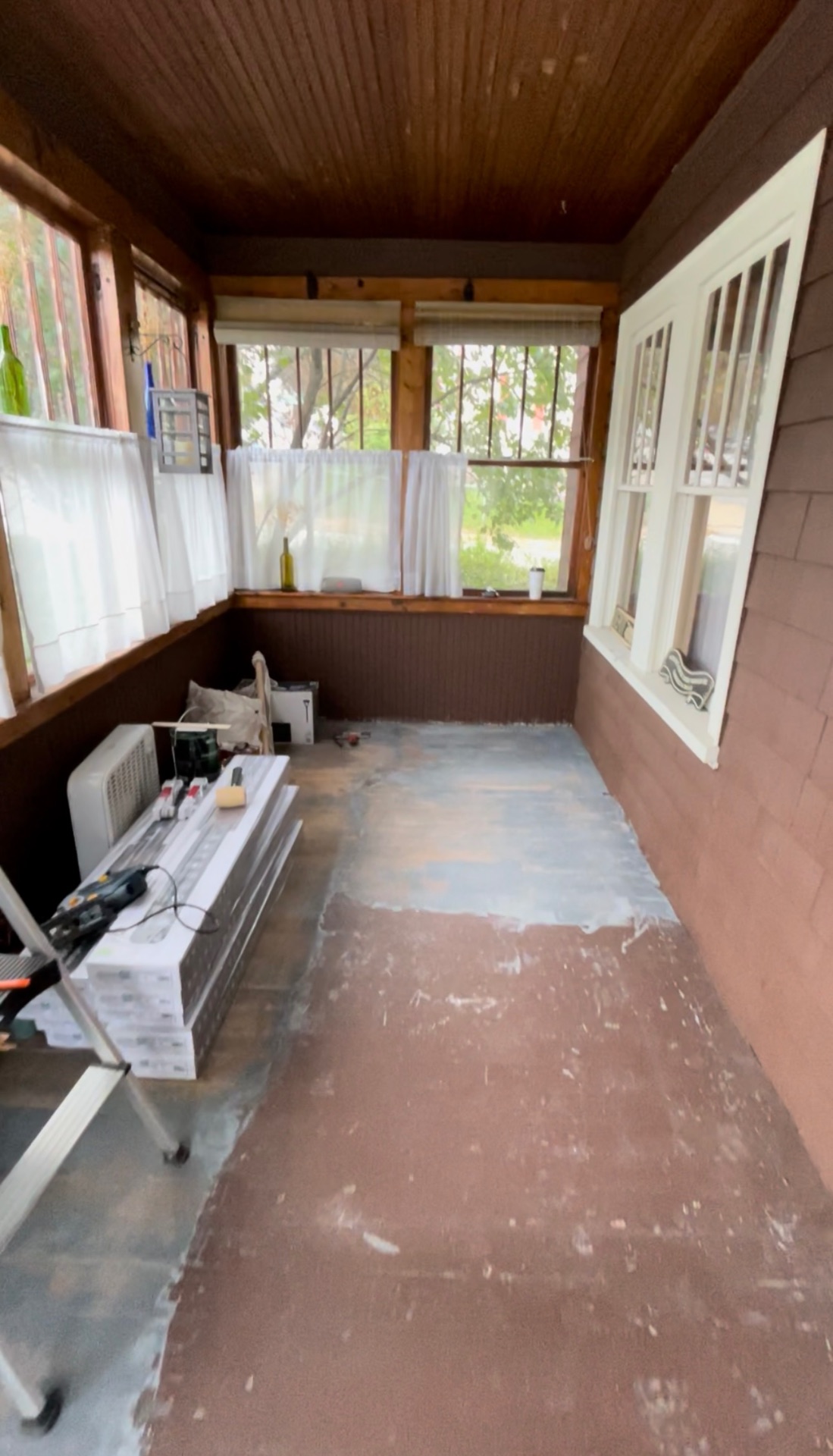 Porch before renovation — bare concrete floor and unfinished walls